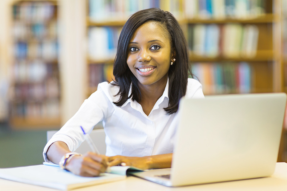 Woman smiling while writing on notebook